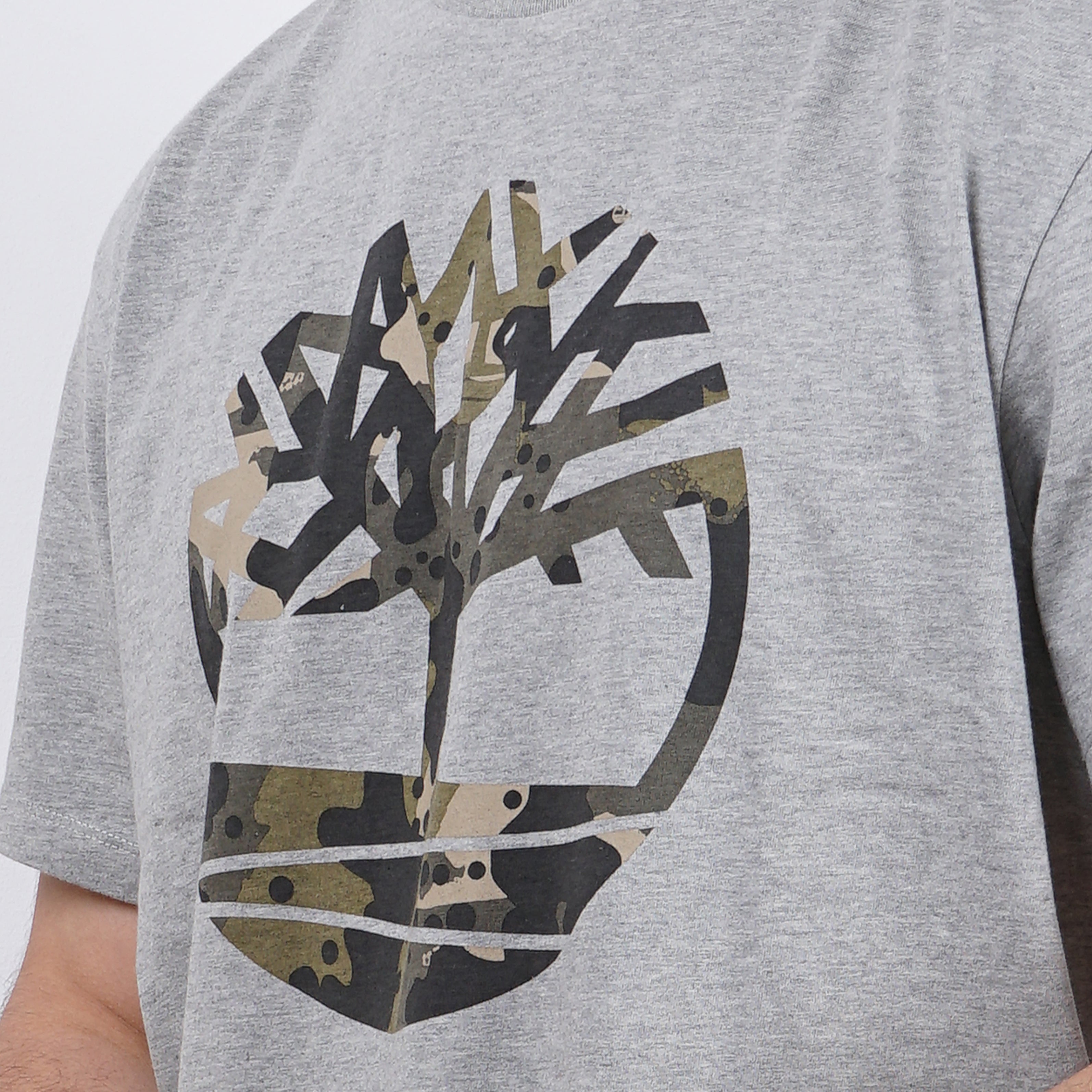 Man in gray t-shirt with camouflage Timberland design.